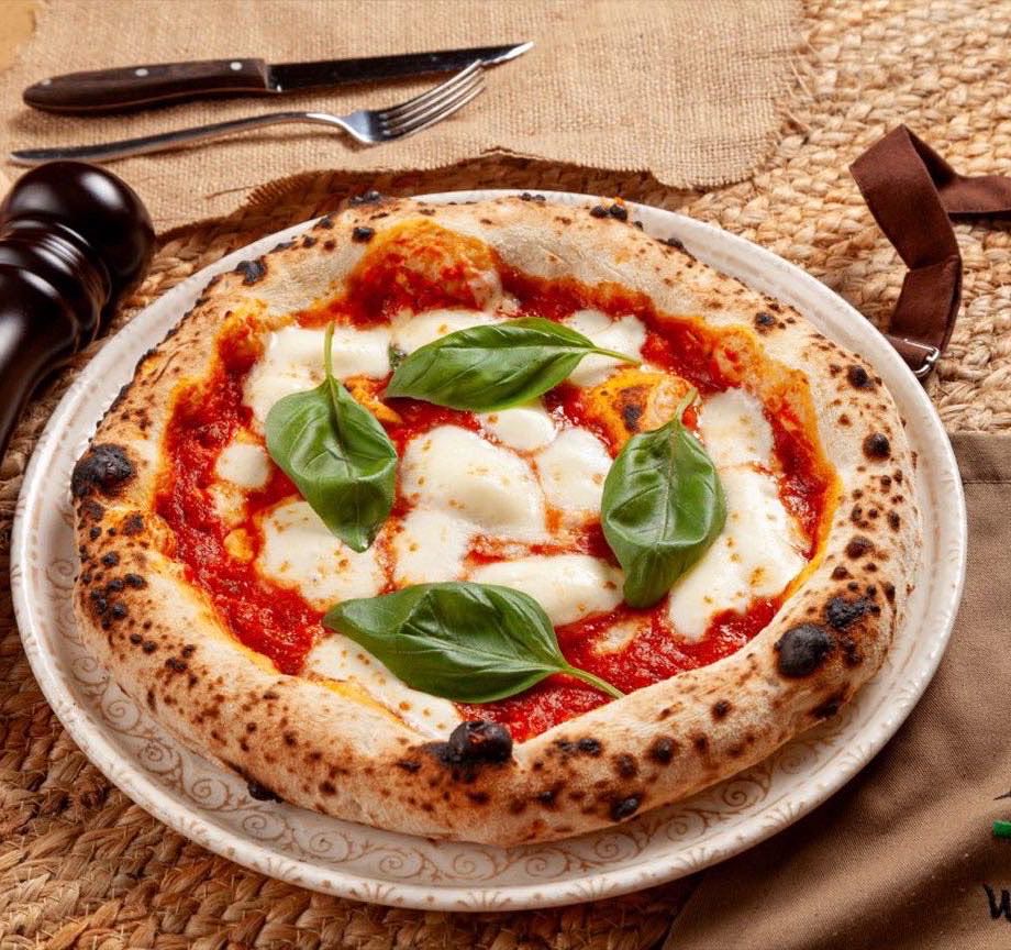 Frisch gebackene Pizza Margherita mit Basilikum