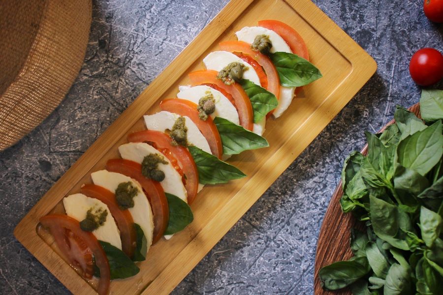 Tomaten, Mozzarella und Basilikum auf einem Holzbrett